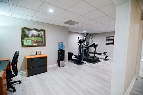 A gym in the basement featuring fitness equipment and art
