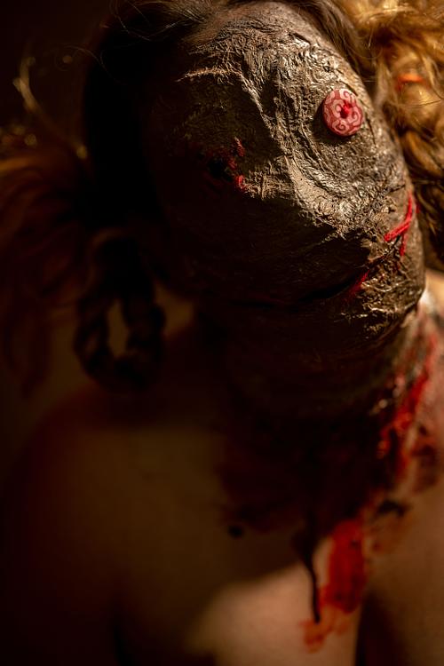 A creepy voodoo doll tilting her head and staring at you with a button eye.