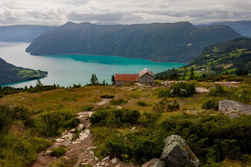 Photographie fine art de lac norvégien turquoise entouré de montagnes, atmosphère paisible.