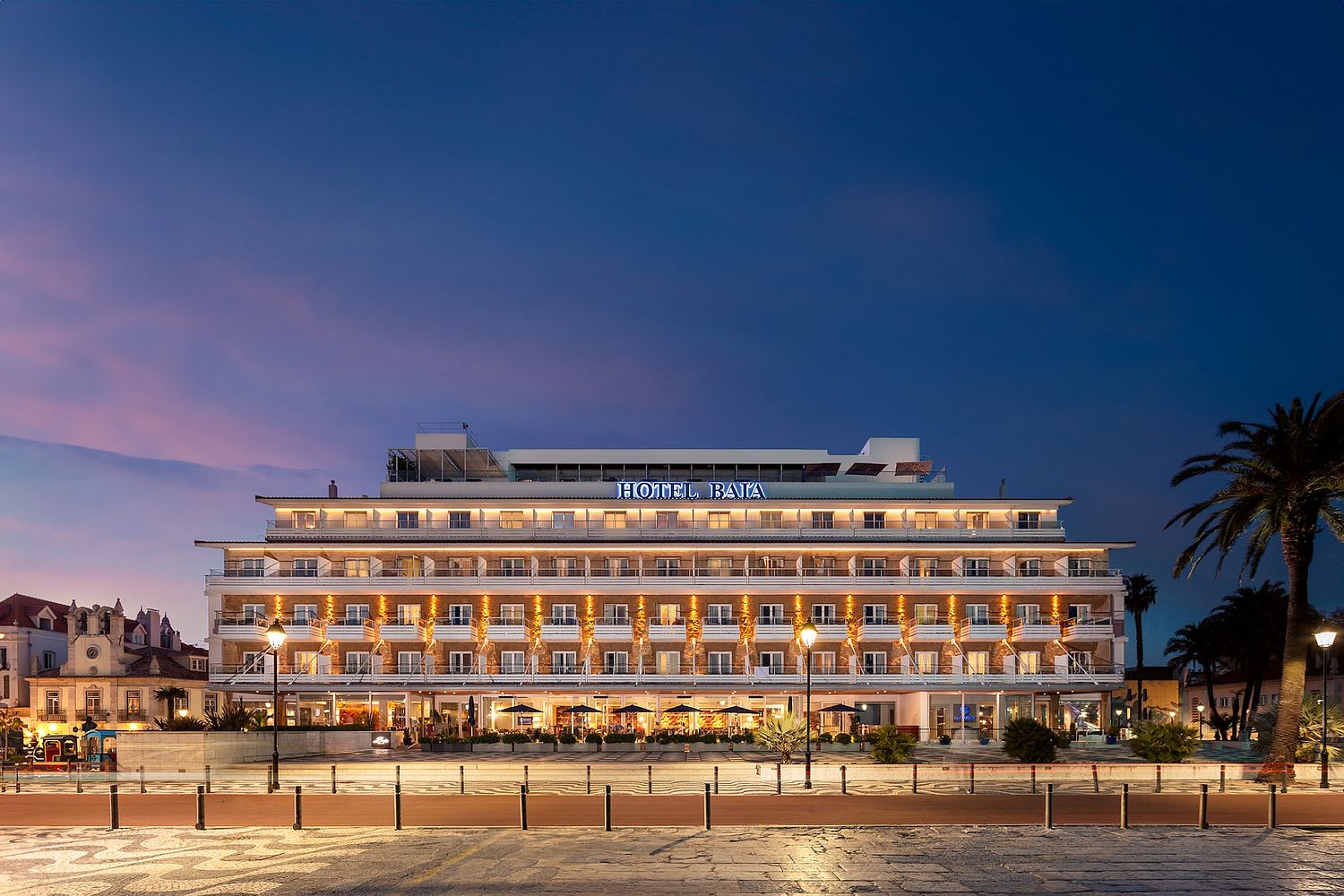 Fachada iluminada do histórico Hotel Baía em Cascais ao anoitecer, fotografada por Pedro Brás Photography — fotografia profissional de arquitetura e hotelaria em Portugal, com especialização em reportagens de hotéis de luxo e património histórico.