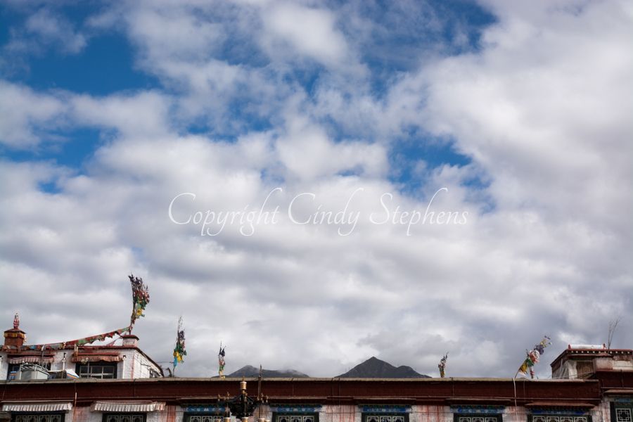 Rooftop of a Tibetan building against a cloudy blue sky as seen from Barkhor square