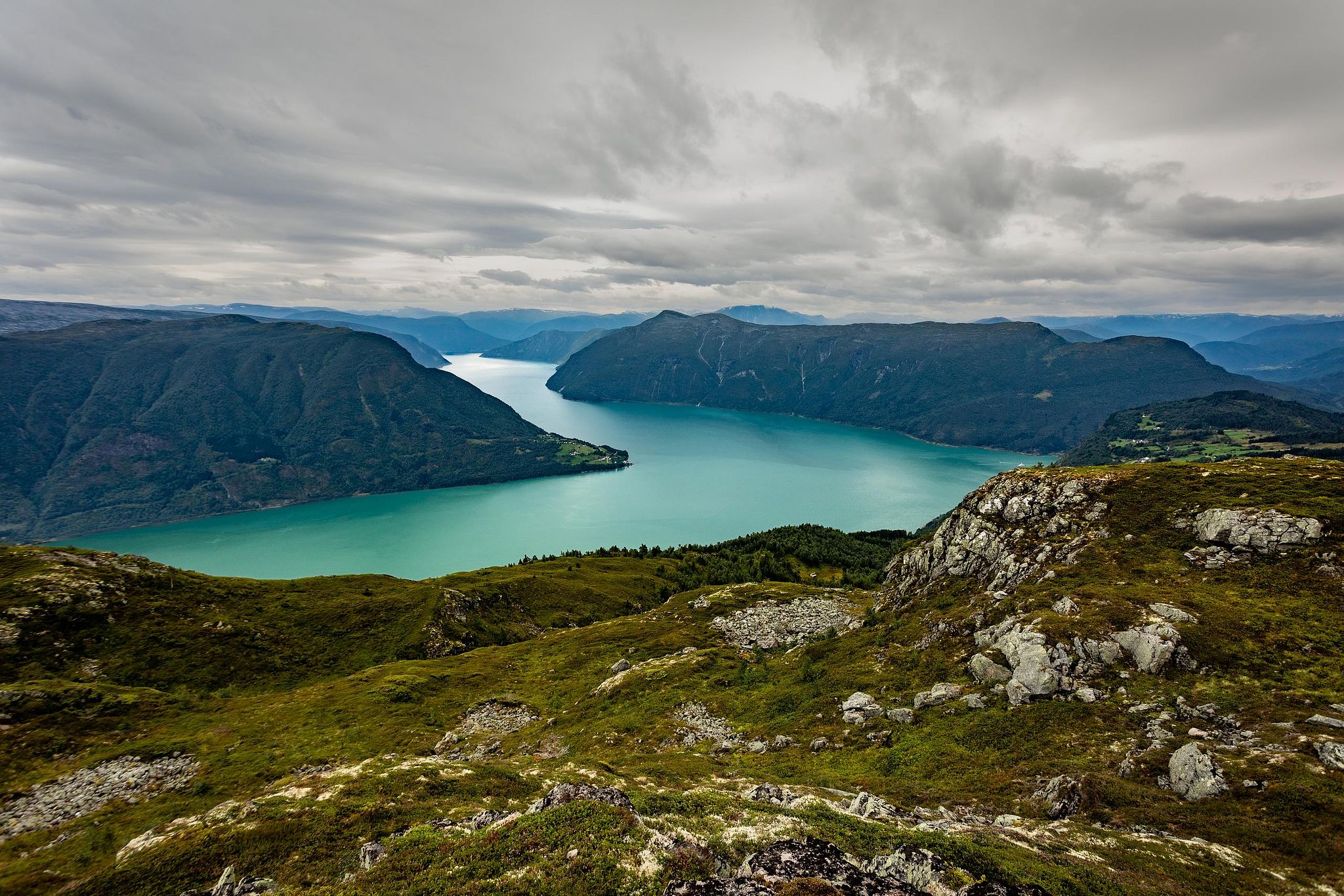 Etendue rocheuse et eau turquoise, ciel couvert.