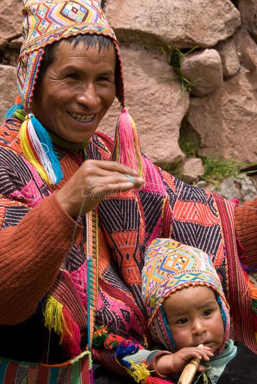 Nicholas and Yuli, a man and child in traditional Peruvian dress, weaving together in a serene landscape near Cuzco, Peru.