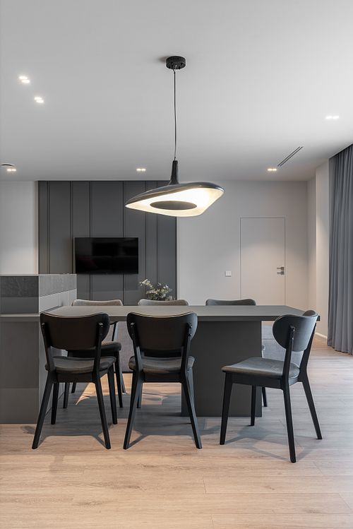 Minimalist dining area in an open-plan space with muted tones – Columna project