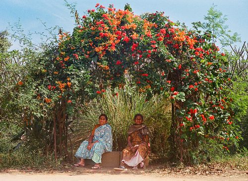 indian women sitting under flower arch Bangalore