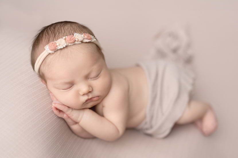 Beautiful baby girl posing on blanket captured by Cypress Newborn Photographer, Amanda Mandola