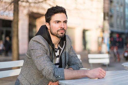 Toni Gojanovic in a gray jacket and striped sitting at the table.