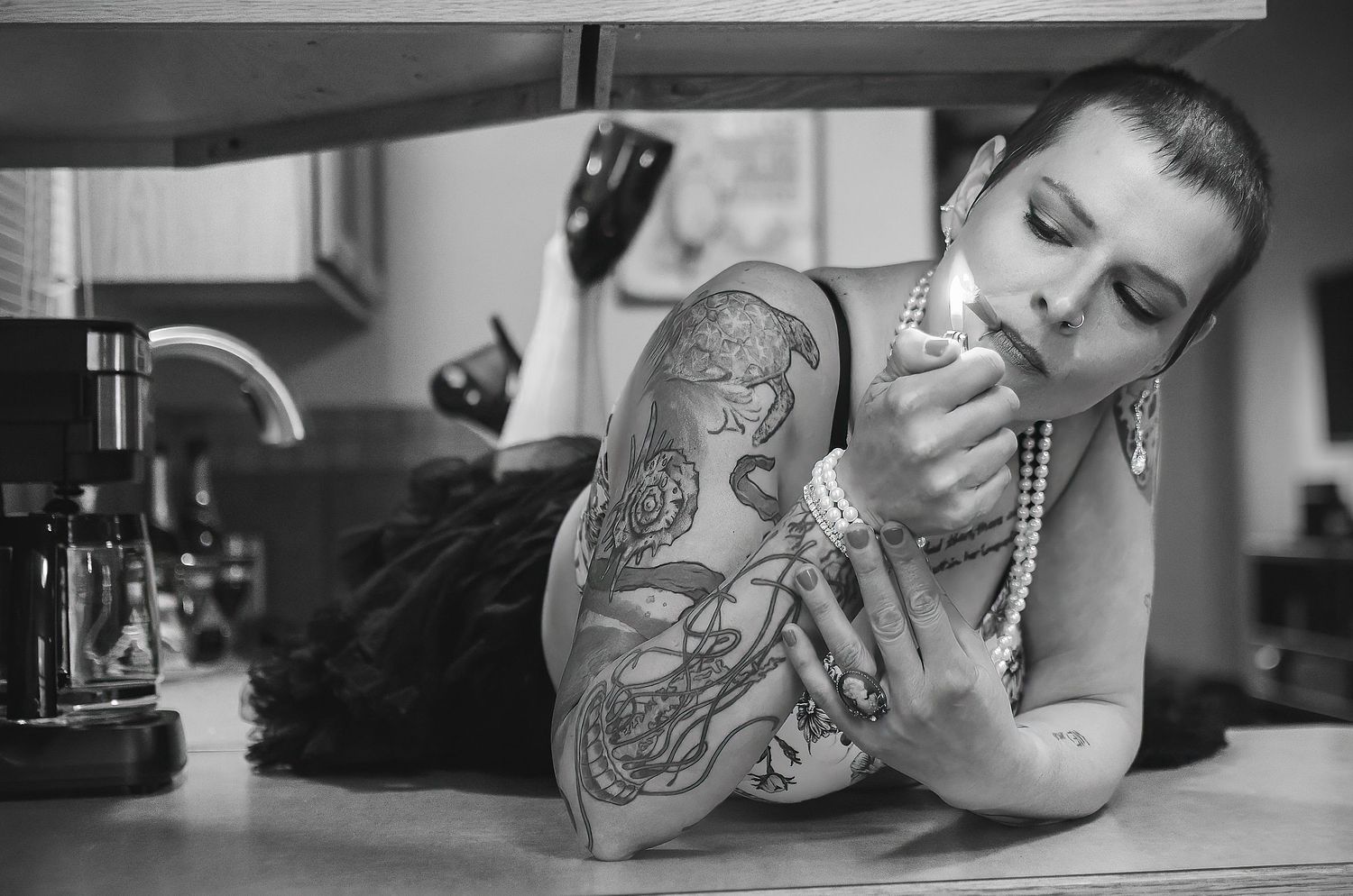 Portrait of woman in black and white lighting a cigarette, editorial.