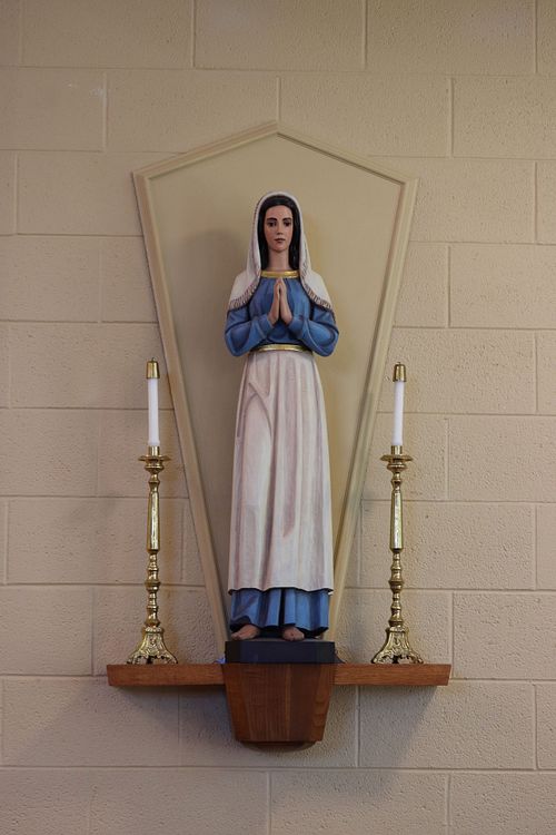 Restored statue of St. Bernadette on mid-century modern pedestal