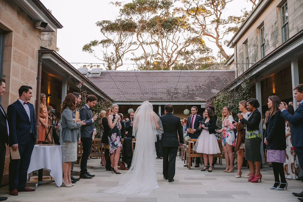 Bride is walking down the aisle during a wedding ceremony at Gunners Barracks Mosman