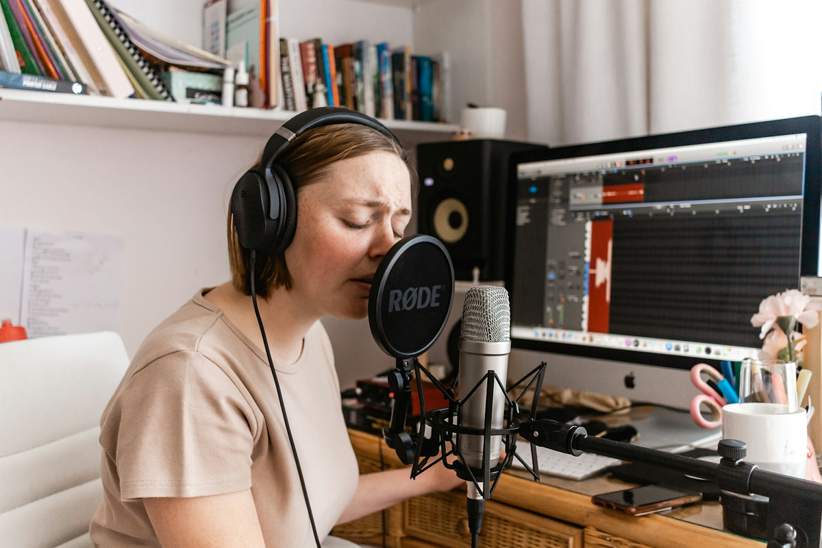 una donna che registra nel suo piccolo studio di casa