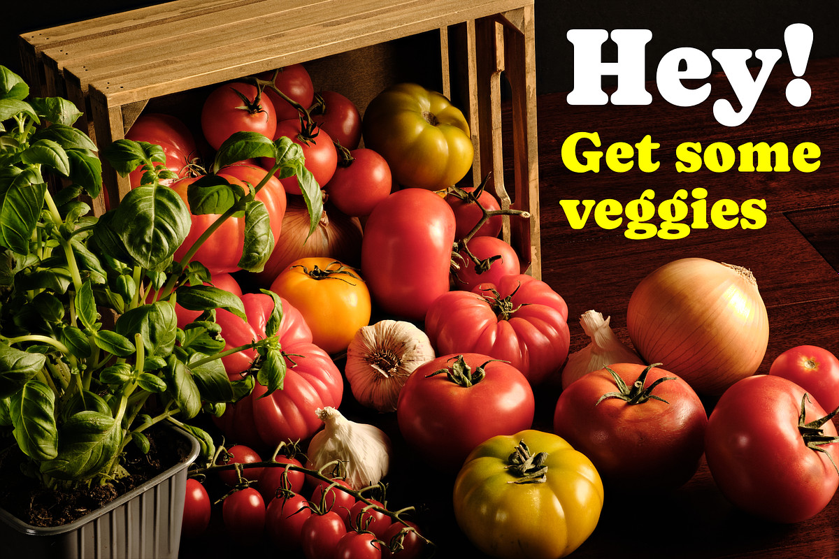 Assortment of fresh produce spilling from a wooden crate with an advertising call to action text overlay.