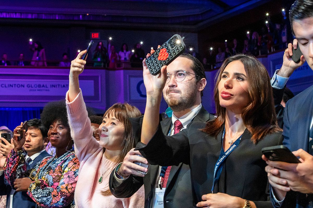 Corporate event photography capturing audience members raising their phones to document a powerful moment during the “Future of Funding” session at the Clinton Global Initiative 2024 in New York City, highlighting collective engagement and shared impact.