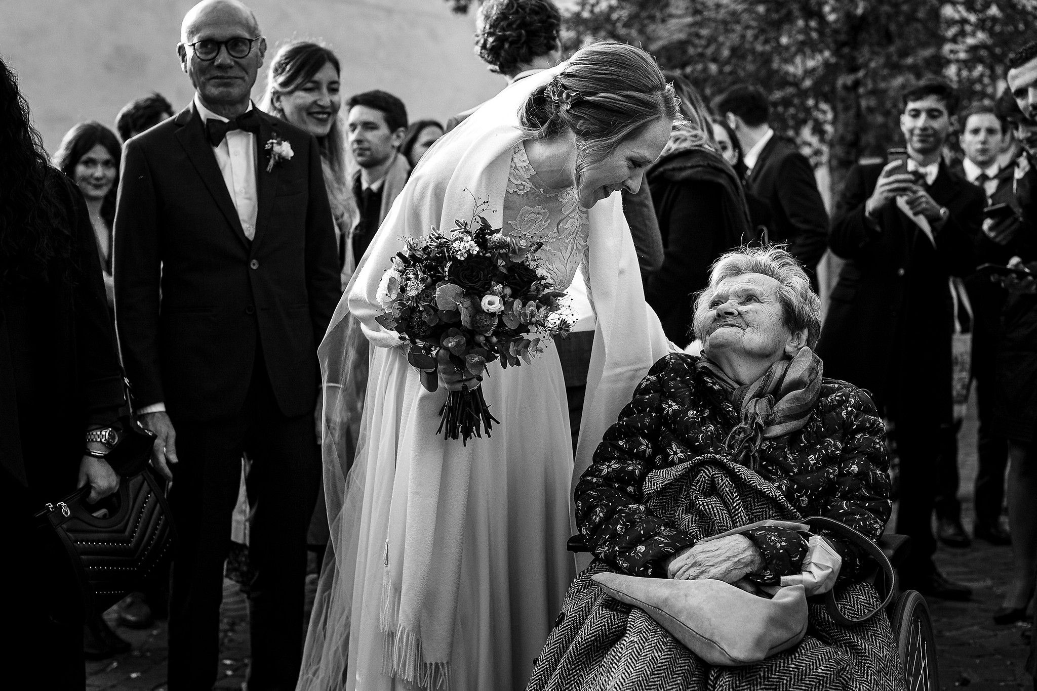 Mari&eacute;e &agrave; la sorte de l'&eacute;glise qui regarde tendrement sa grand-m&egrave;re captur&eacute; par S&eacute;bastien CLAVEL photographe de Mariage &agrave; Lyon et Gen&egrave;ve