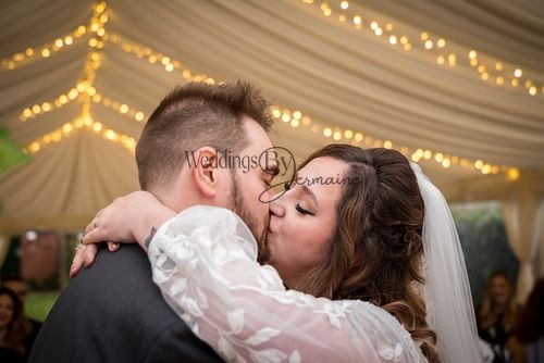 The bride and groom sharing their first kiss as newlyweds during the wedding ceremony, captured by Weddings By Jermaine.