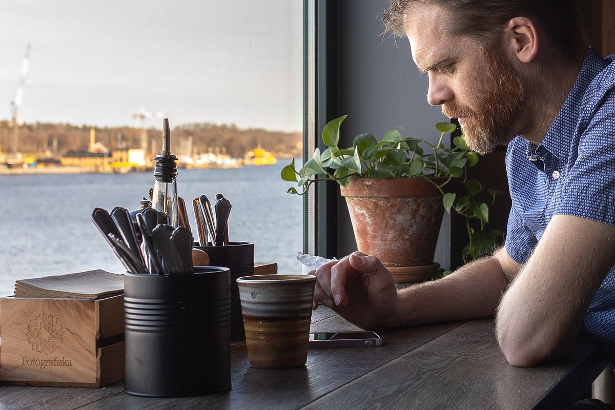 Man vid f&ouml;nsterbord med kaffe och utsikt &ouml;ver vattnet p&aring; Fotografiska