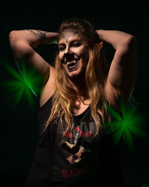 A self-satisfied werewolf raising her arm behind her head with a smirk and is wearing a piggy t-shirt.