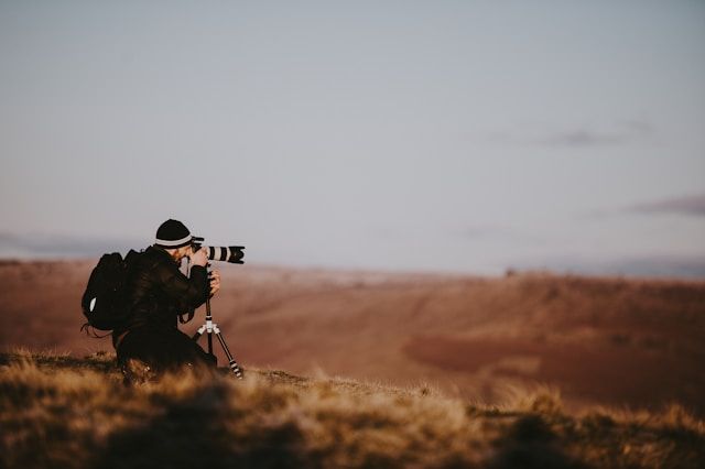 Image of a photographer clicking a landscape photo