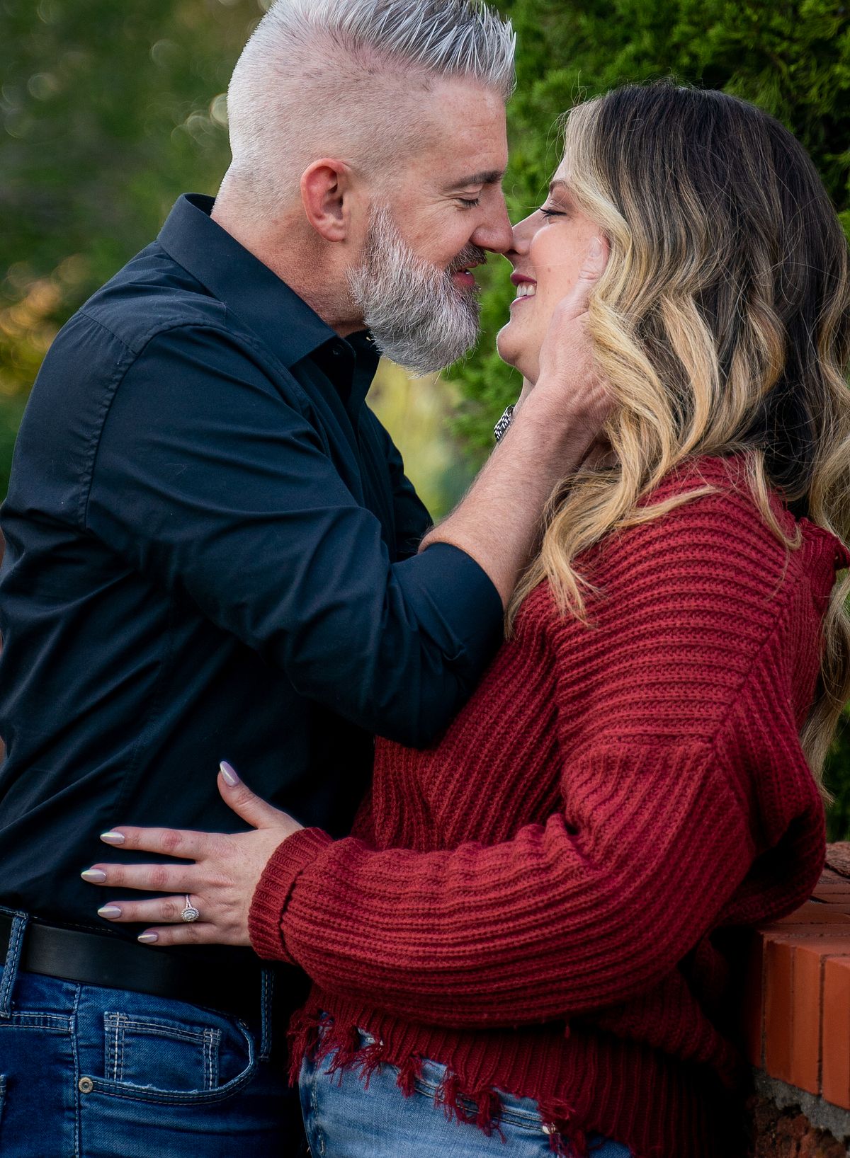 Engaged couple sharing a candid moment during golden hour in Oklahoma.