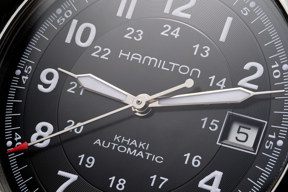Macro detail of a black field watch face.