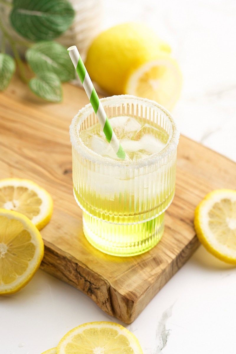 Cup of lemonade with lemon slices around it