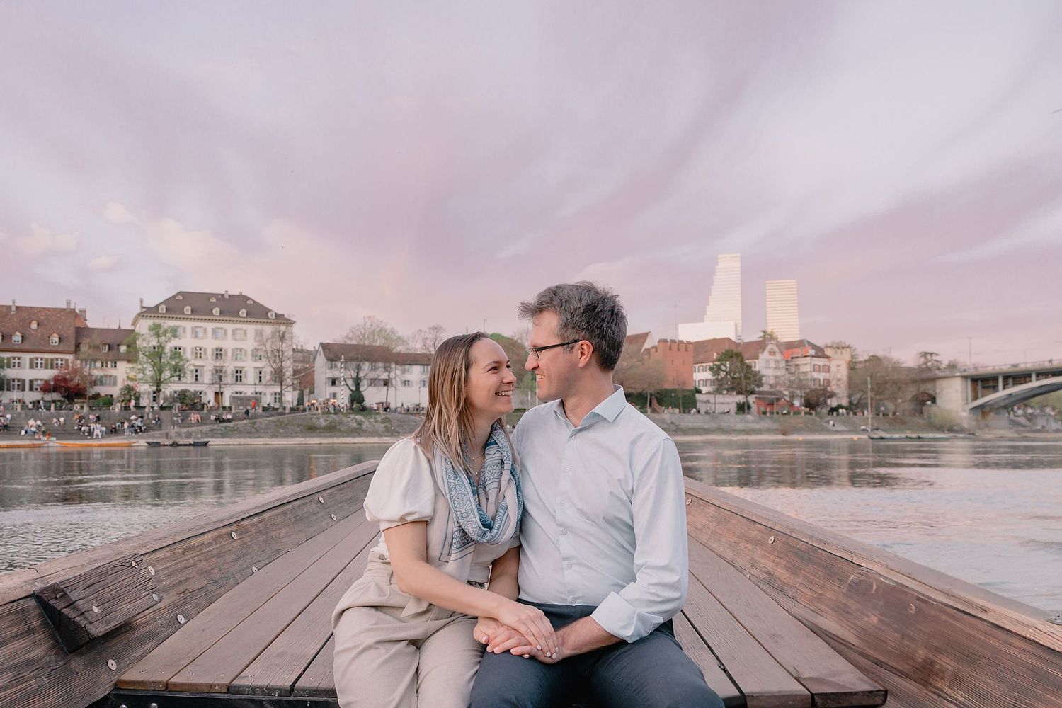 International tourist couple enjoying Basel photo walk with professional photographer on a boat on the Rhine river in Switzerland