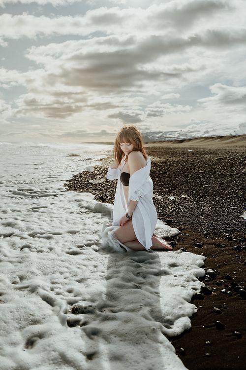 Solo female portrait in white shirt at Diamond beach, Iceland