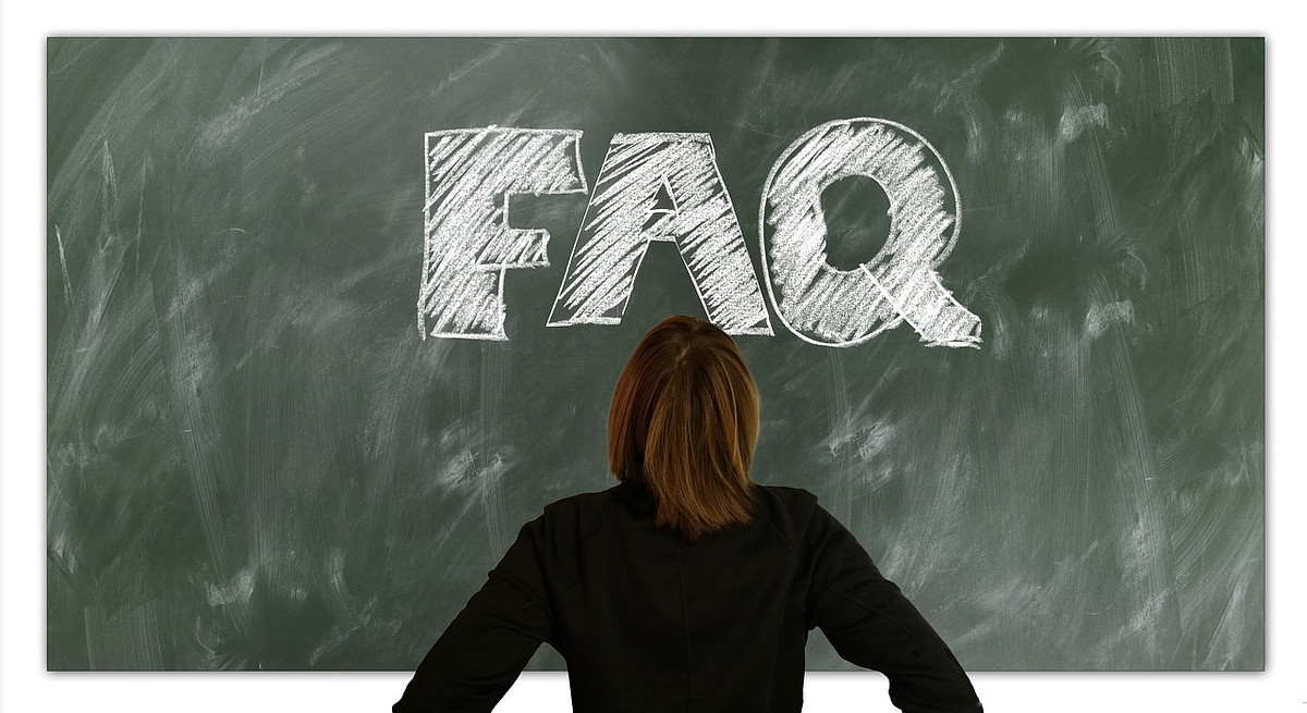 woman in front of blackboard with Frequently Asked Questions
