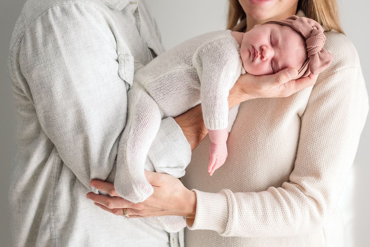 husband and wife holding sleeping newborn baby girl in natural light with cranberry township, pa newborn photographer