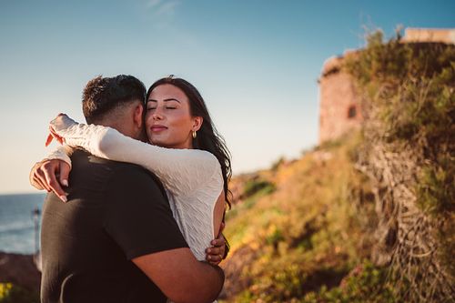 fidanzati abbracciati davanti alla torre di portoscuso
