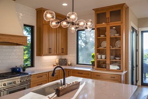 Chandelier over workstation sink with a view of a large window beyond