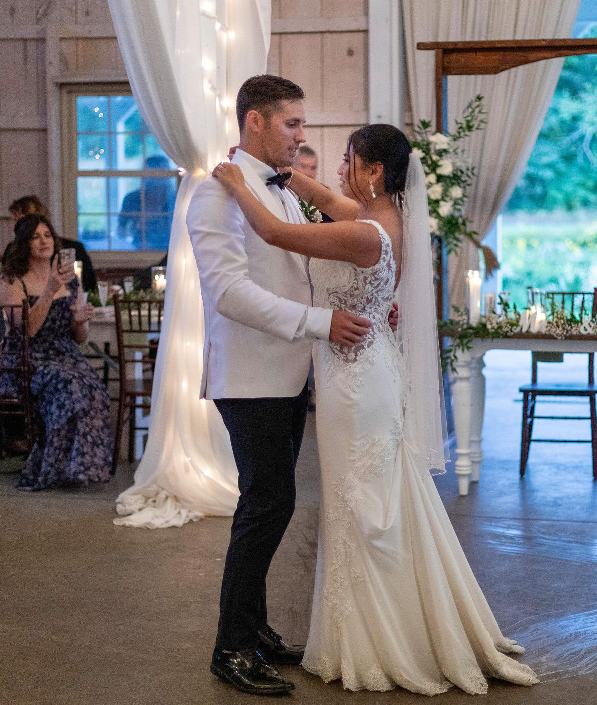 first dance with the bride wearing a gown from downtown bridal salisbury md. the groom is wearing a white tux jacket and black pants