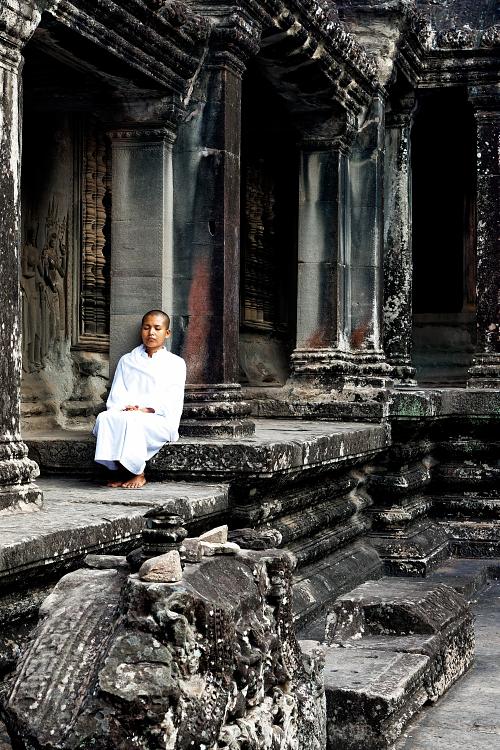 Portrait d'une jeune femme en méditation dans le temple d'Angkor au Cambodge