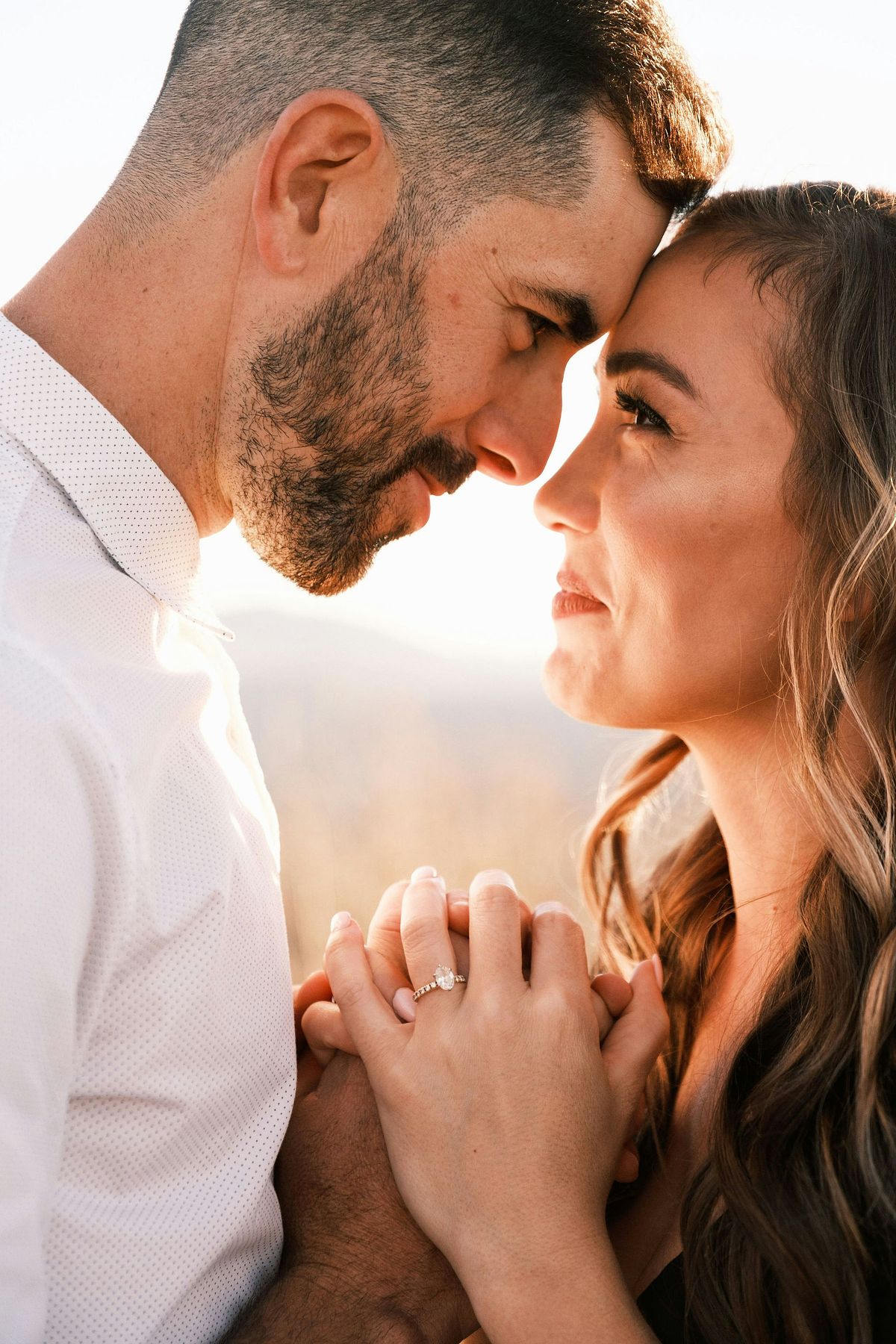 Engaged couple sharing a candid moment during golden hour in Oklahoma.