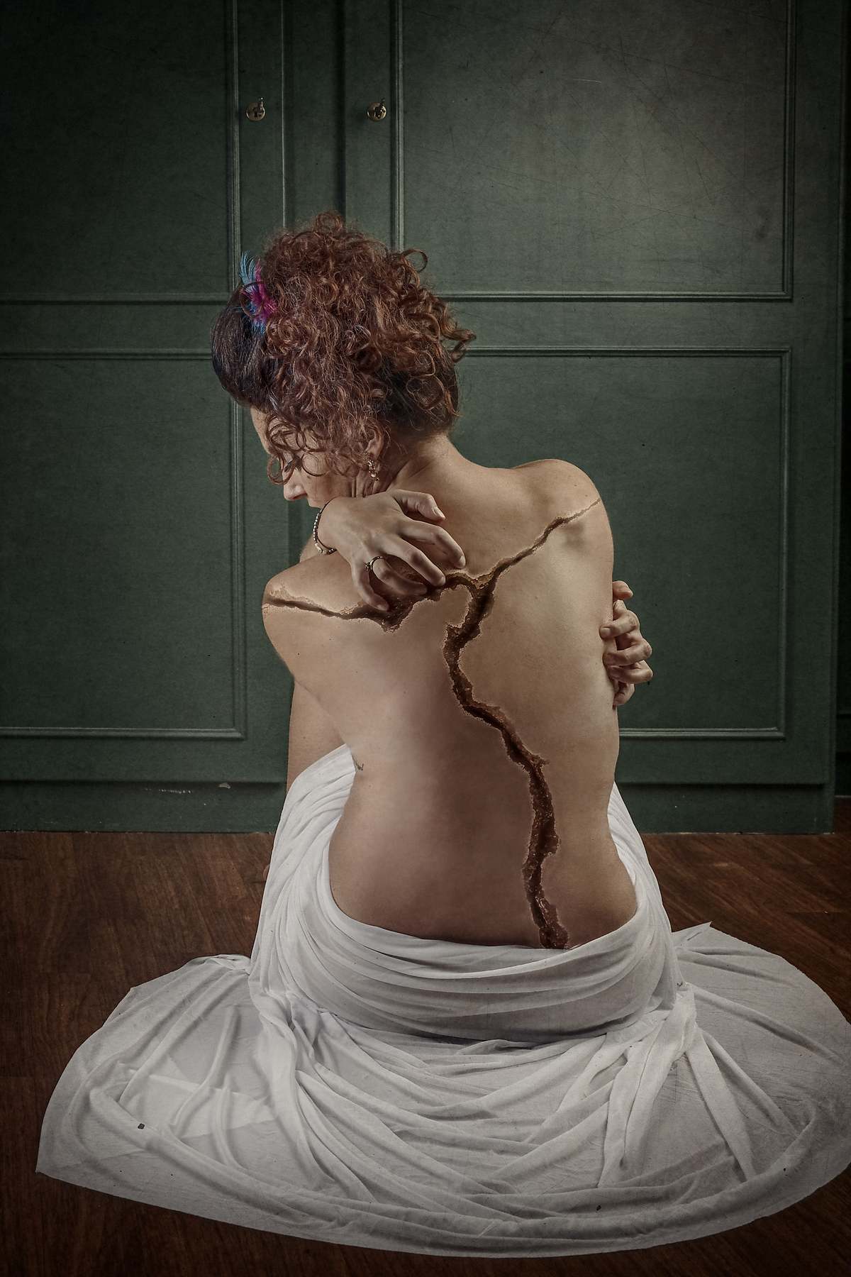photo tarot Broken, femme vue de dos avec fissure dans le dos et regard baiss&eacute;, &eacute;voquant douleur et r&eacute;silience