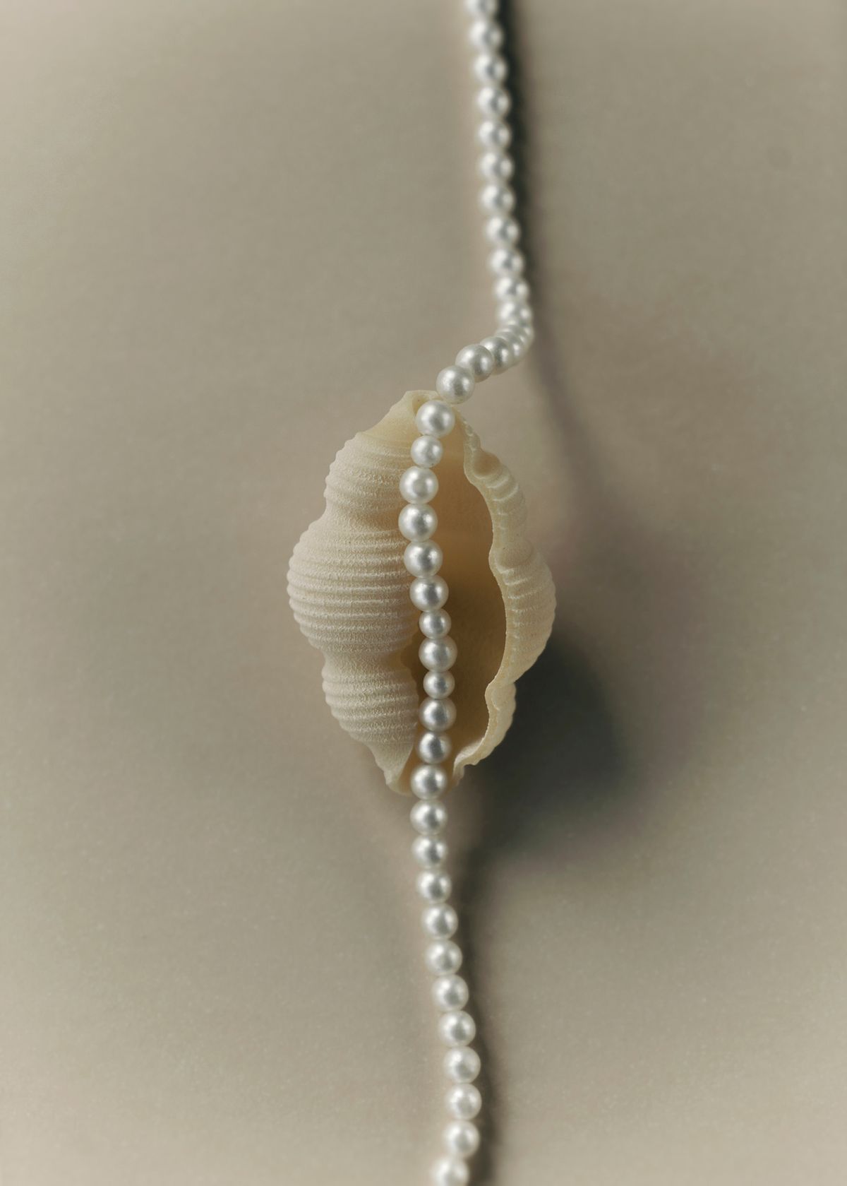 Editorial photo of a pearl necklace places on a pasta seashell. Photographed by Filianna Karamanli.