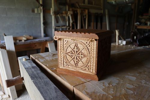 shows the other side of the carved oak box with its wooden pintle hinge