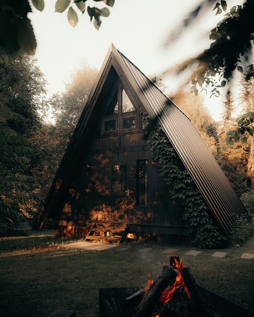 Black A-frame cabin exterior with warm evening light