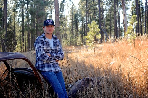 Young man against a vintage car with golden grass