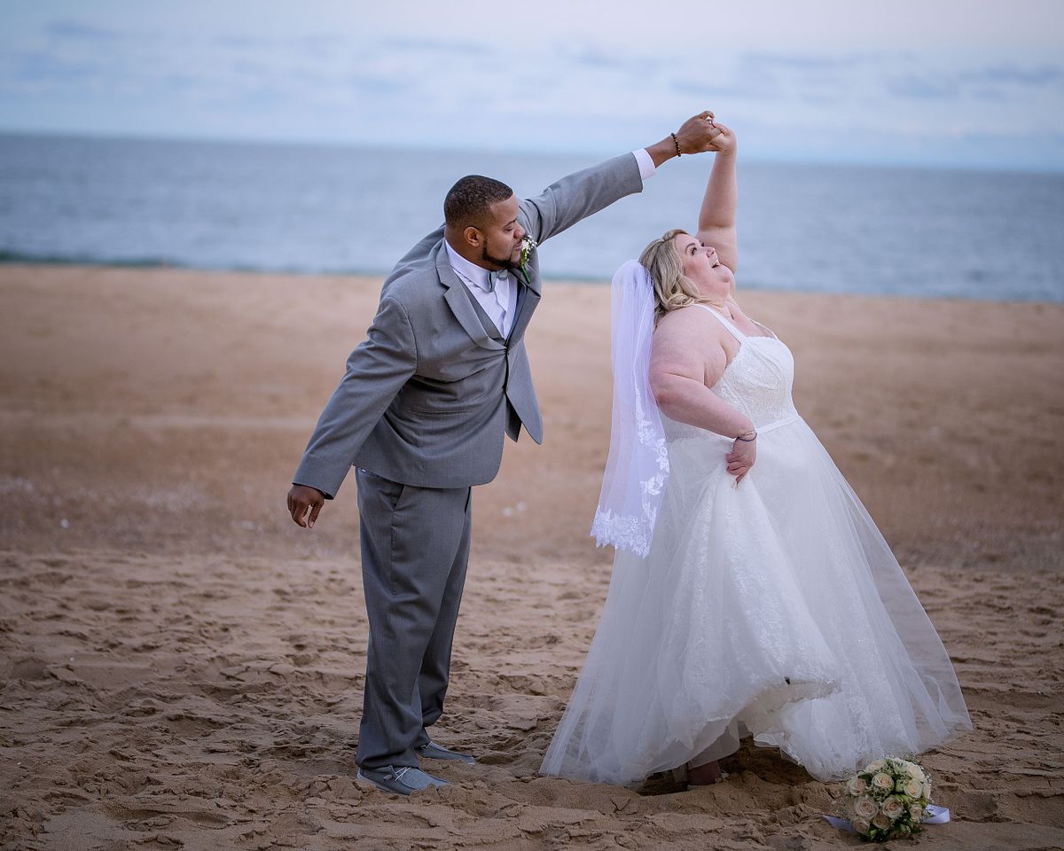 Bride and groom dancing on an empty beach in Ocean City Maryland during October wedding