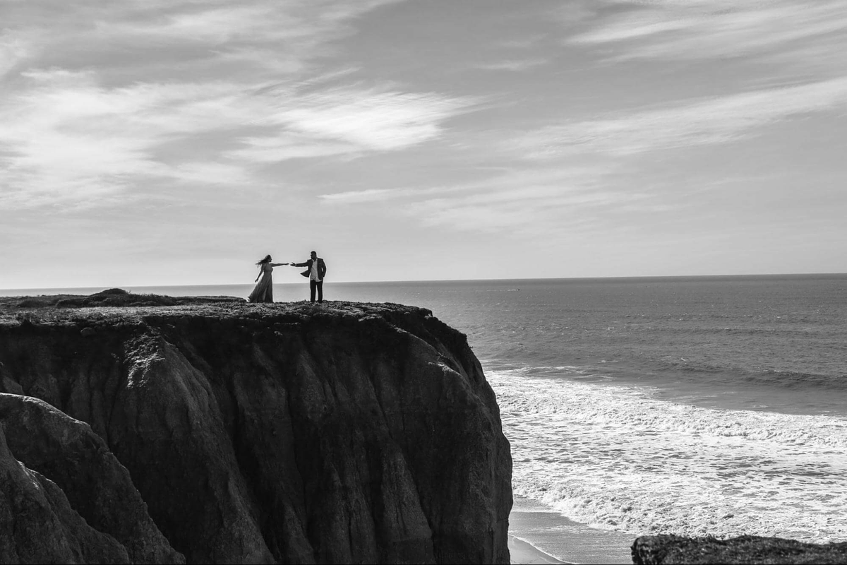 Image of two models posing on a cliff next to the sea