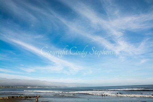 Small figures against a vast beach and ocean landscape