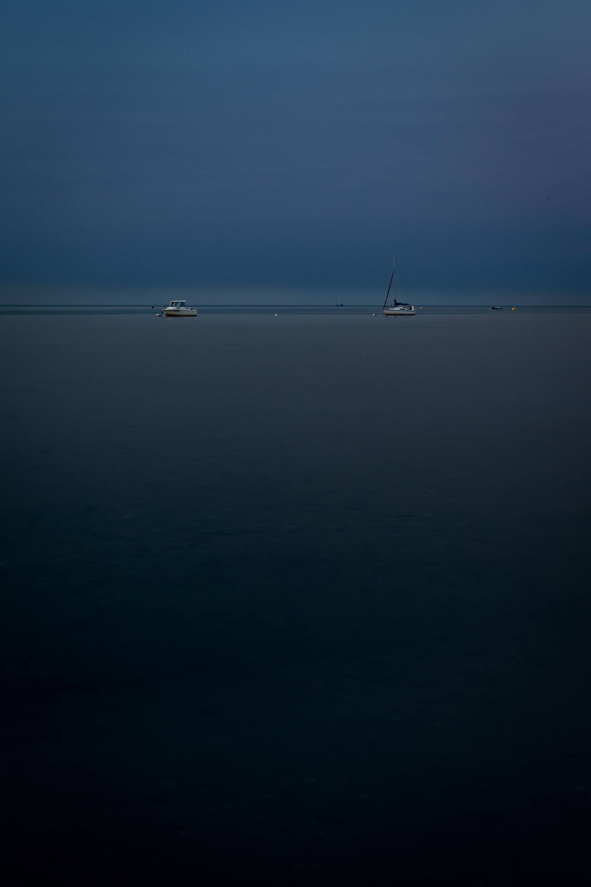 Plan d’eau sombre sous ciel uniforme.