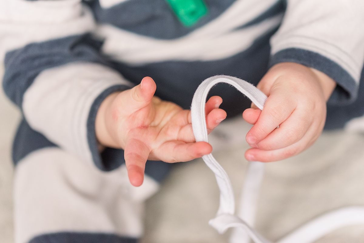 up-close of baby hands exploring small, soft rope in Cranberry Township, PA