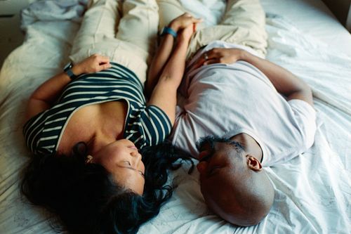 couple holding hands in bed