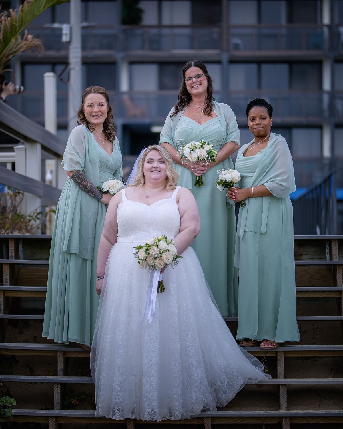 bride posing with her bridesmaid on the stairs at the Golden Sands in ocean city maryland photographed by eastern shore wedding photographer