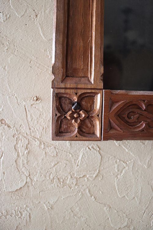 close up of a gothic quatrefoil with a virgin's bower flower in the middle on the carved frame for a painting of the Blessed Virgin Mary