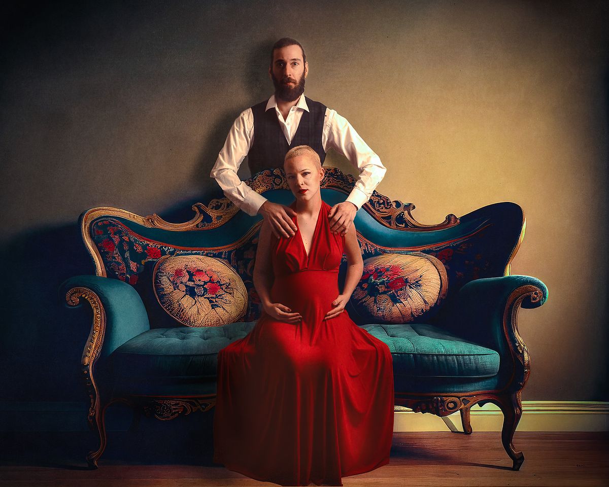 photo tarot couple attendant un enfant, femme en robe rouge et homme debout derrière elle, atmosphère solennelle et intime