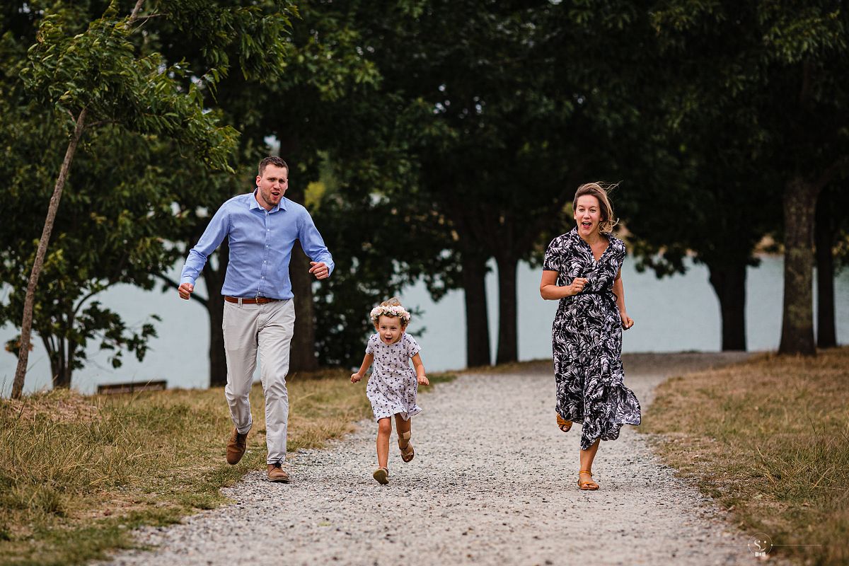 Famille s'amusant &agrave; courir lors d'une s&eacute;ance photo &agrave; Lyon avec un photographe de famille professionnel