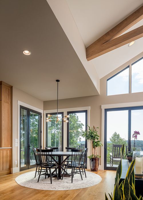 round dining room table in the corner surround by floor to ceiling windows. It opens to the great room.